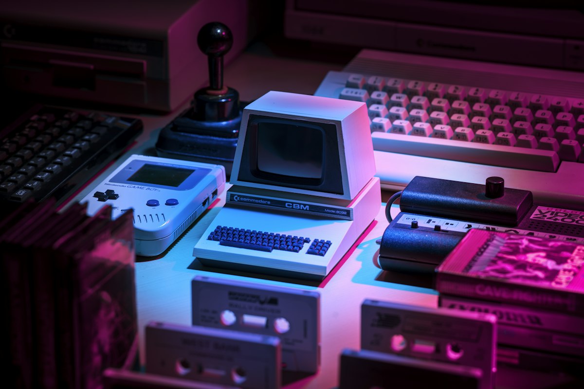 Ordinateurs et consoles rétro sous un éclairage violet